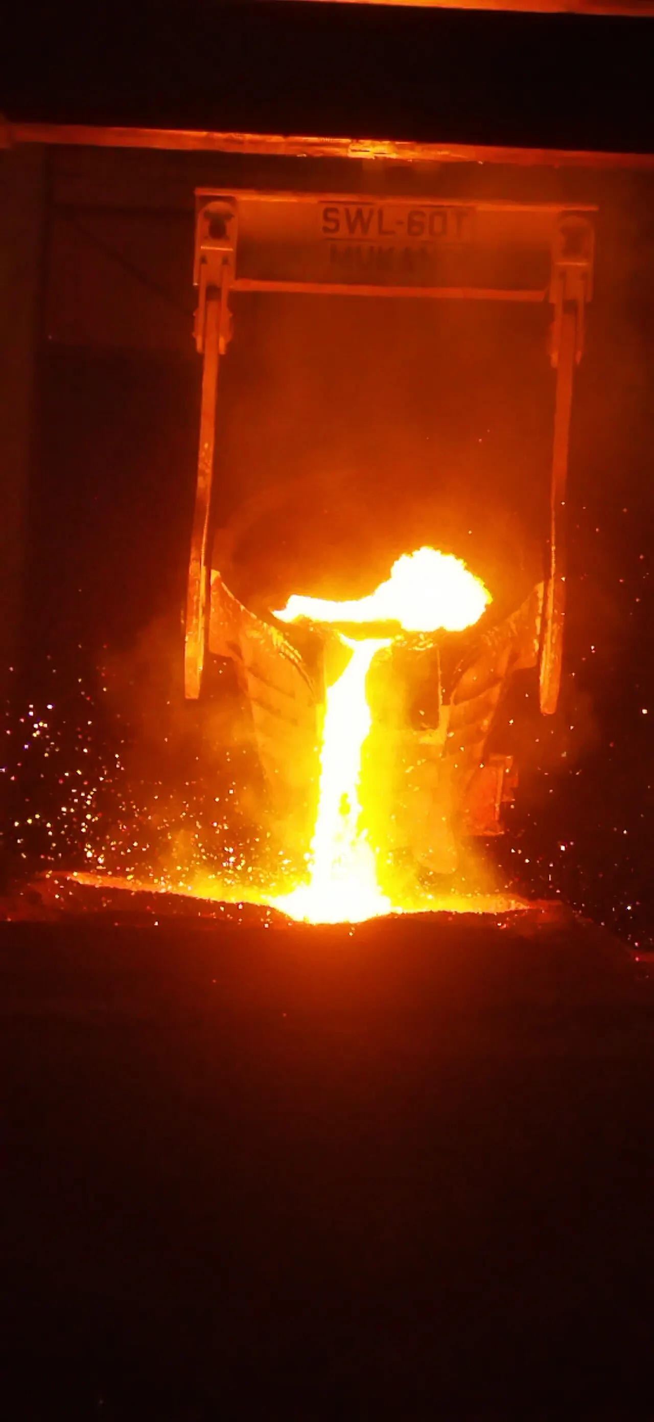 Molten metal pouring from a foundry ladle
