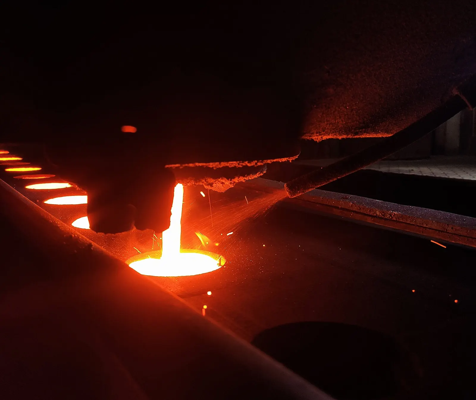 Molten iron being poured into a green sand mould